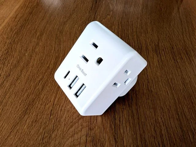 OneBeat white Travel Adapter on wooden floor