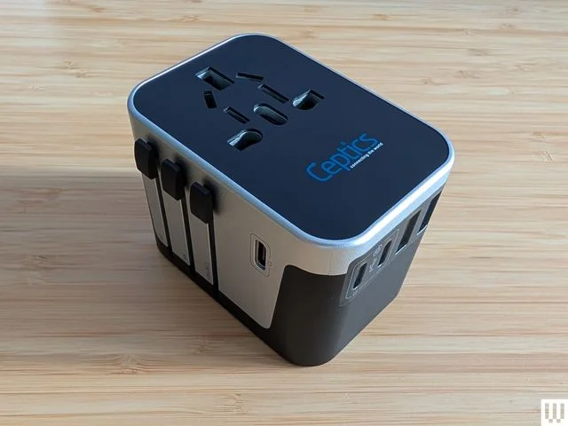 Ceptics 6 in 1 Worldwide Travel Adapter a small black and silver electronic block with ports and outlets