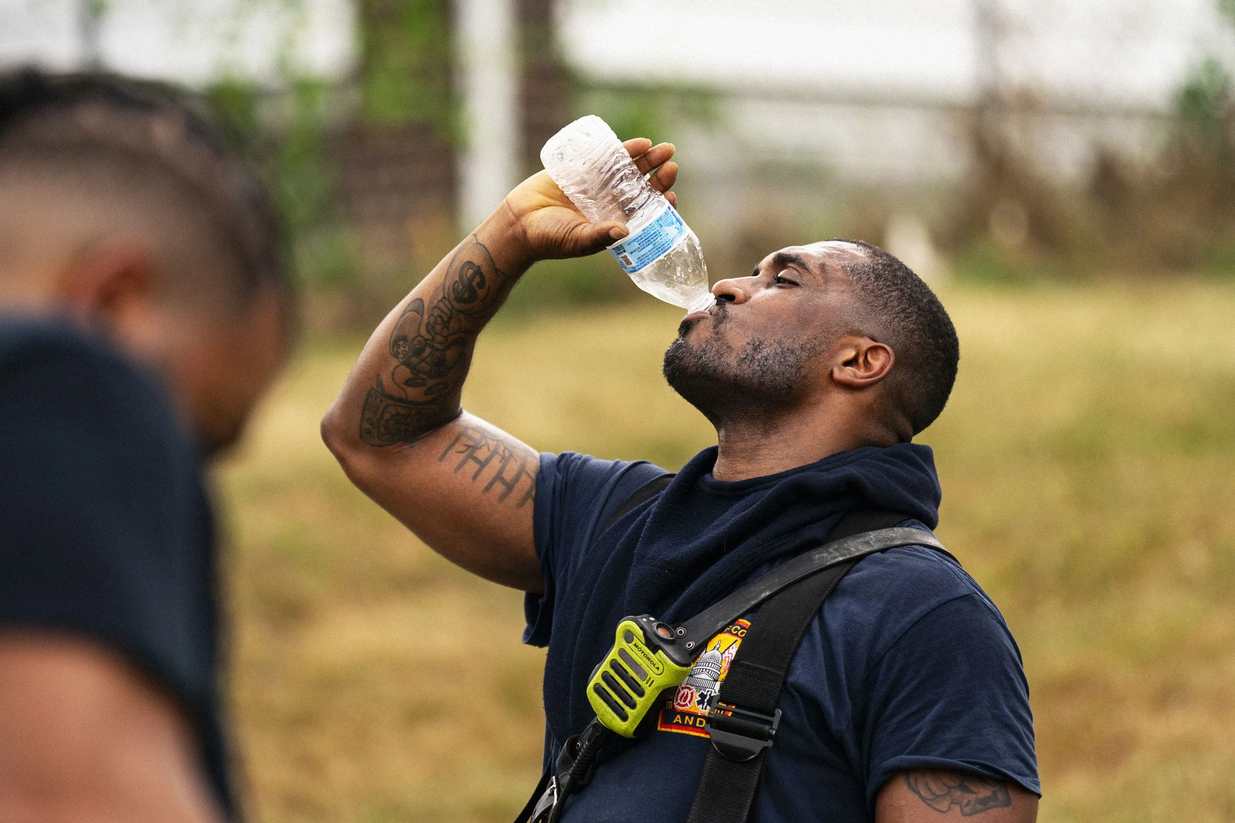 A firefighter drinks water following a kitchen fire during high temperatures in Washington DC US on Sunday June 23 2024....