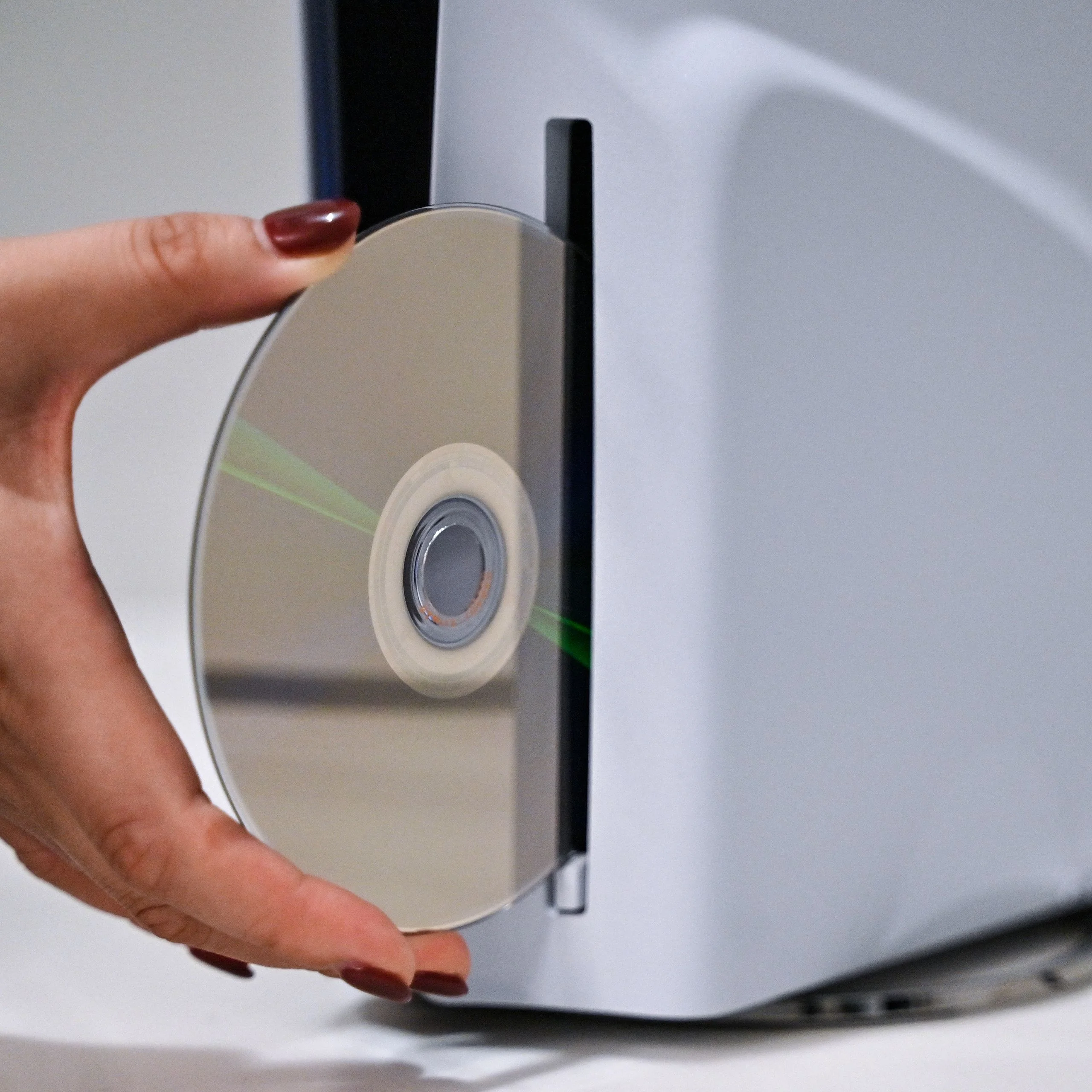 A PlayStation employee demonstrates how to put a disc into the PlayStation 5.