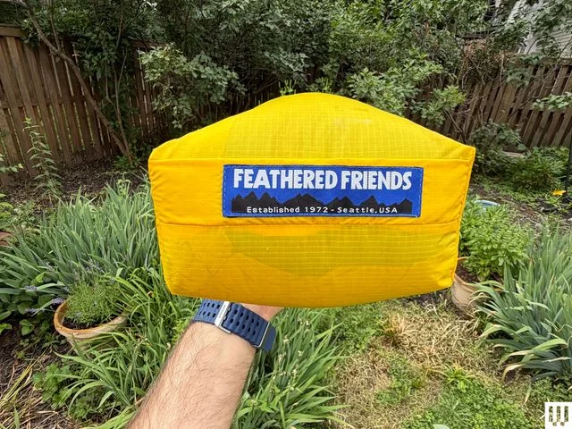 Image may contain: Cushion, Home Decor, Bag, Clothing, Vest, Cap, Hat, Grass, and Plant
