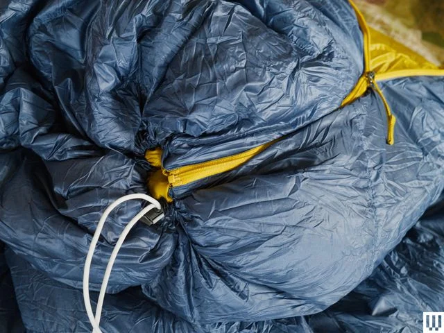 Closeup of puffy navy blue quilt with yellow zipper