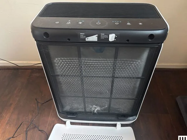 Front of rectangular air purifier with the front panel open to show the filter inside