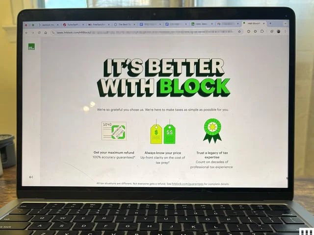 Closeup of an open laptop with the screen showing H&R Block tax filing software