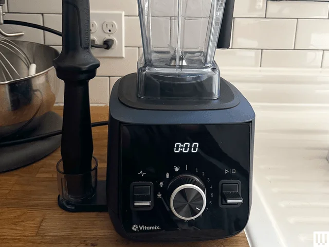 Front view of the Vitamix Ascent X2, a blender with a square black base, extended rod on the side, and clear container