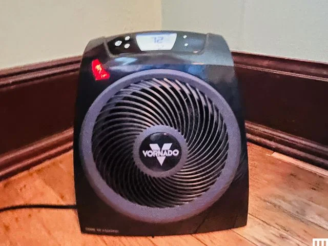 Small black fan on a wooden floor