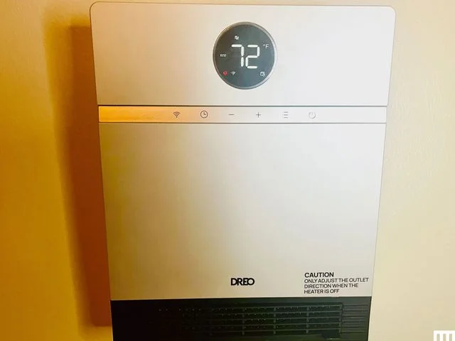 Dreo Smart WallMounted Heater with ALCI plug a white rectangular wall unit with small circular digital screen on top