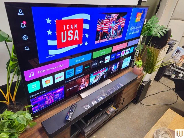 Side view of L.G. C.4. O.L.E.D. television, a large screen tv with app thumbnails on the screen
