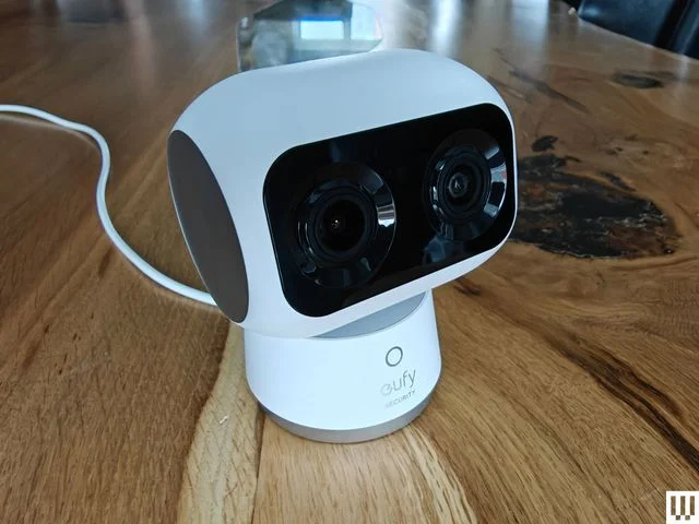 Robotic shaped indoor security camera sitting on wooden surface