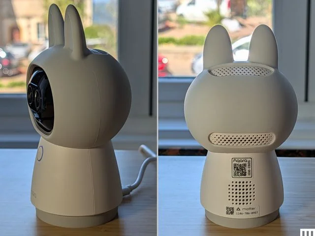 Side and rear view of a home camera in the shape of a white cute figure with pointy ears, the screen for the face, and a cone shaped body