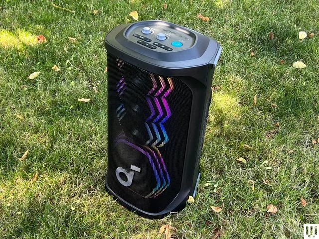 Front view of the Anker Soundcore Rave 3S, a black cylindrical speaker with front lights, sitting in the grass